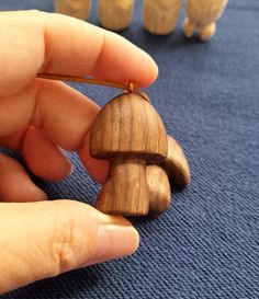 a person is holding a small wooden figurine