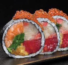 three sushi rolls with different types of vegetables