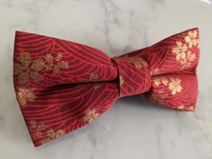 Upgrade your wardrobe in style with this stunning red and gold floral pattern bow tie. Perfect gift for him, this unique adjustable bow tie will elevate any occasion including weddings, birthdays and anniversaries. Comes pre-tied. Elegant Red Bow With Butterfly Knot, Adjustable Red Satin Bow, Red Bow With Butterfly Knot For Party, Elegant Red Bow For Gift, Red Satin Bow Tie Adjustable, Adjustable Red Satin Bow Tie, Elegant Red Bow Tie As Gift, Red Adjustable Bow Tie With Bow Tie Back, Adjustable Red Bow Tie With Bow Tie Back