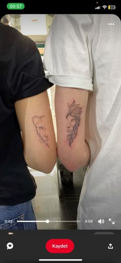 two people holding hands with tattoos on their arms, one has a fish and the other has a bird