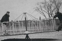 two men are playing with a large metal structure