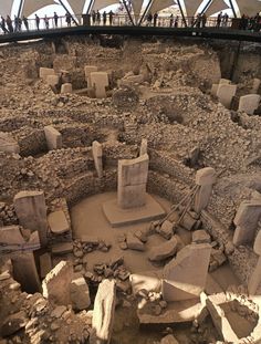 an ancient site with rocks and stones in the foreground, surrounded by other ruins