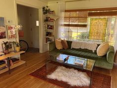 a living room filled with furniture and a glass table on top of a wooden floor