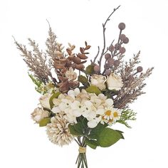 a vase filled with lots of white flowers and greenery on top of a table