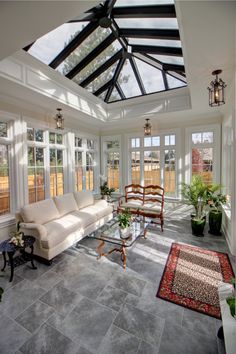 a living room filled with lots of furniture under a glass ceiling covered in light shinning