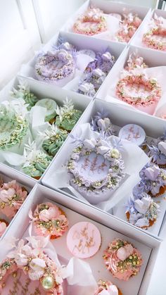 many different types of buttons in boxes on a table with flowers and ribbons around them