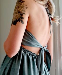 the back of a woman's dress with tattoos on it