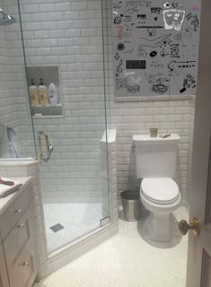 a white toilet sitting next to a walk in shower