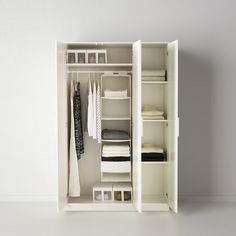 an open white closet with clothes and other items