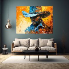 a living room with a couch, table and painting on the wall above it that has a cowboy hat on it