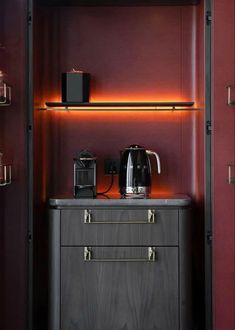 a coffee maker on top of a cabinet in a room with red walls and shelves