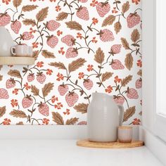 a white vase sitting on top of a counter next to a wallpapered wall