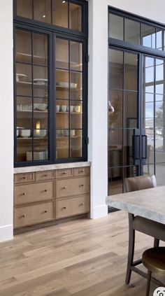 an empty dining room with wooden floors and large windows