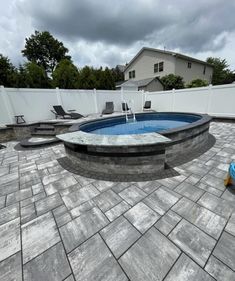 a small pool in the middle of a patio with chairs and a fire hydrant