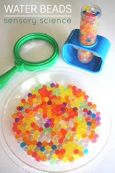 a bowl filled with gummy bears next to a pair of scissors