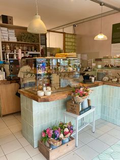 the inside of a bakery with flowers on display