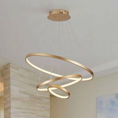 a modern chandelier hanging from the ceiling in a living room with white walls