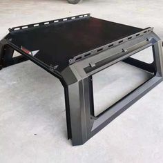 a black table sitting on top of a white floor next to a fork lift truck