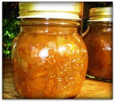 two jars filled with food sitting on top of a wooden table