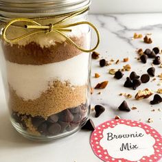 a jar filled with brownie mix sitting on top of a counter next to a tag