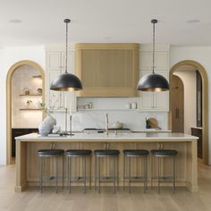 a large kitchen with an island and bar stools