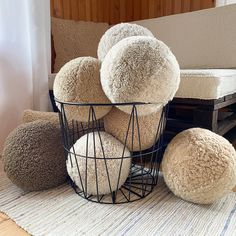 a basket filled with fluffy balls on top of a rug