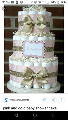 a pink and gold diaper cake with polka dots, bows and a name on it