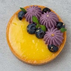 a yellow and purple dessert with blueberries on top