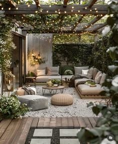 an outdoor living area with couches, tables and lights