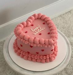 a pink heart shaped cake sitting on top of a white plate