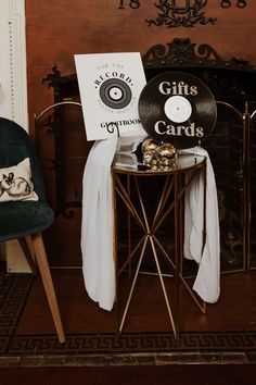 a table with a record on it next to a chair and a sign that says gifts cards