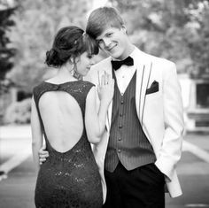 a man in a tuxedo standing next to a woman