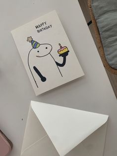 a birthday card sitting on top of a table next to an envelope with a piece of cake