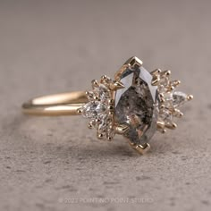 a diamond ring sitting on top of a gray table next to a pair of scissors