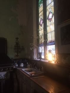 an old kitchen with stained glass windows and wooden counter tops in front of the sink