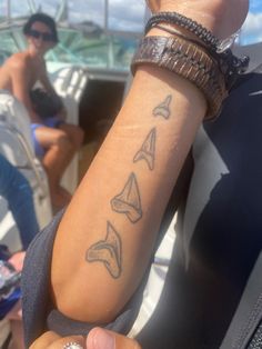 two people on a boat with tattoos on their arm