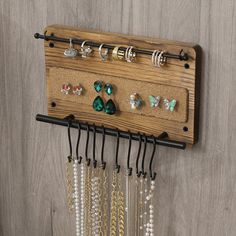 a wall mounted jewelry rack with several pairs of earrings