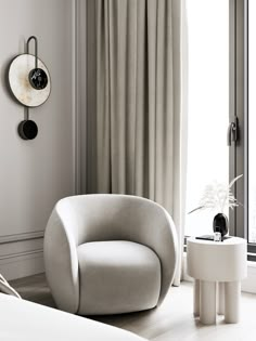 a white chair sitting next to a window in a room