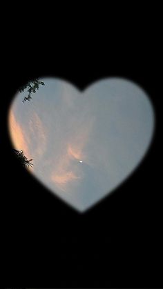 a heart shaped window with the sky in the background