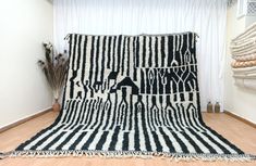 a large black and white rug on top of a wooden floor