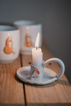 a tea cup and saucer with a lit candle