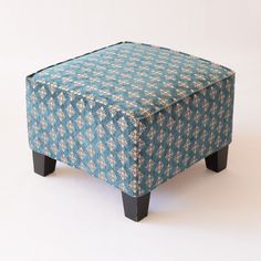 a small blue ottoman sitting on top of a white floor