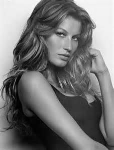 a black and white photo of a woman with her hair blowing in the wind, wearing a tank top