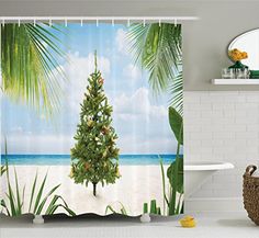 a bathroom with a shower curtain that has a christmas tree on the beach in front of it