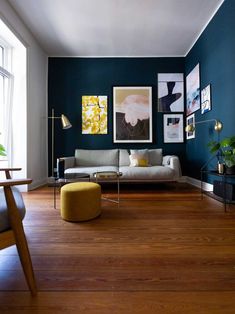 a living room filled with furniture and pictures on the wall next to a wooden floor