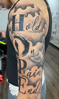 a man with a black and white tattoo on his arm that says hold on rain ends