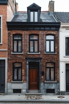 an old brick house with black shutters and windows