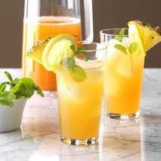 three glasses filled with drinks sitting on top of a marble counter next to each other