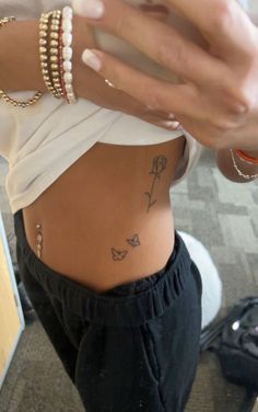 a woman with tattoos on her stomach holding a cell phone