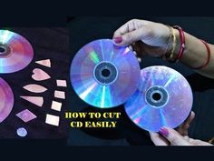 two cds are being held up to show how to cut cd disks with scissors and tape